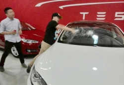 Рассерженый покупатель из Китая рабзил у Tesla лобовое стекло